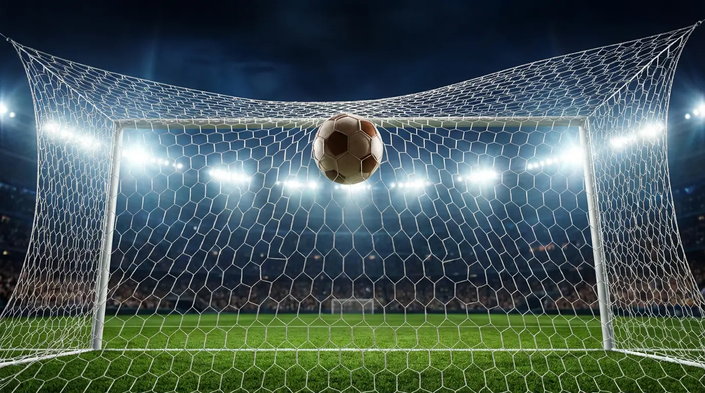 Rete da calcio vista da vicino con pallone che entra in porta sotto i riflettori